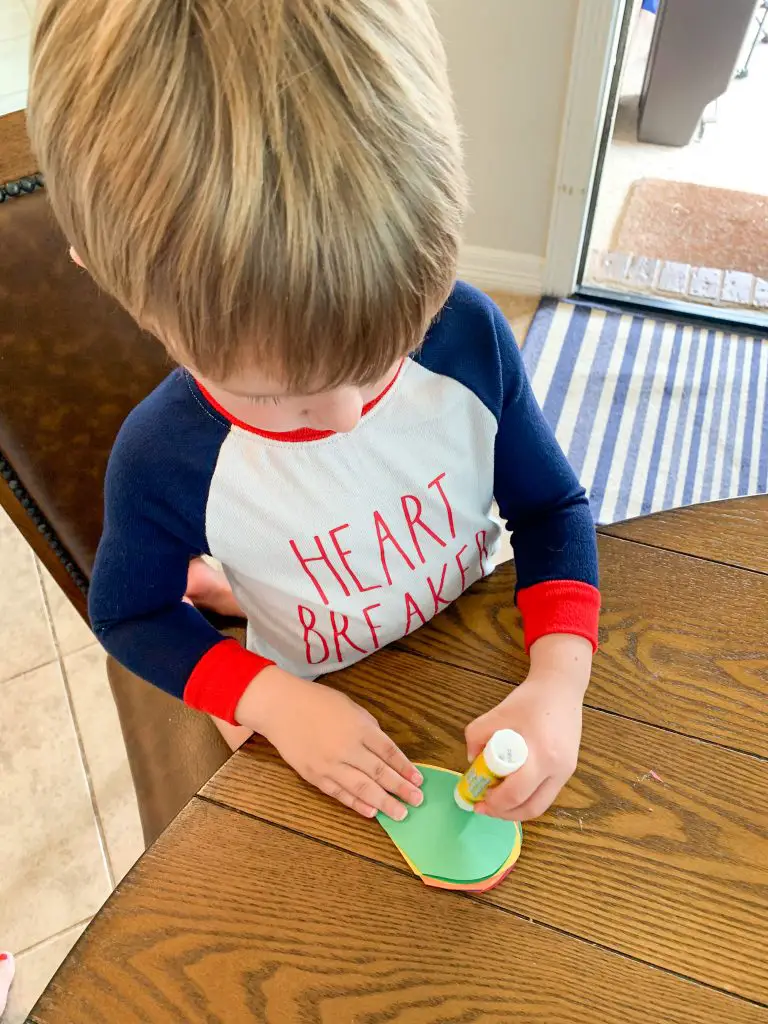Toddler gluing together hearts for garland